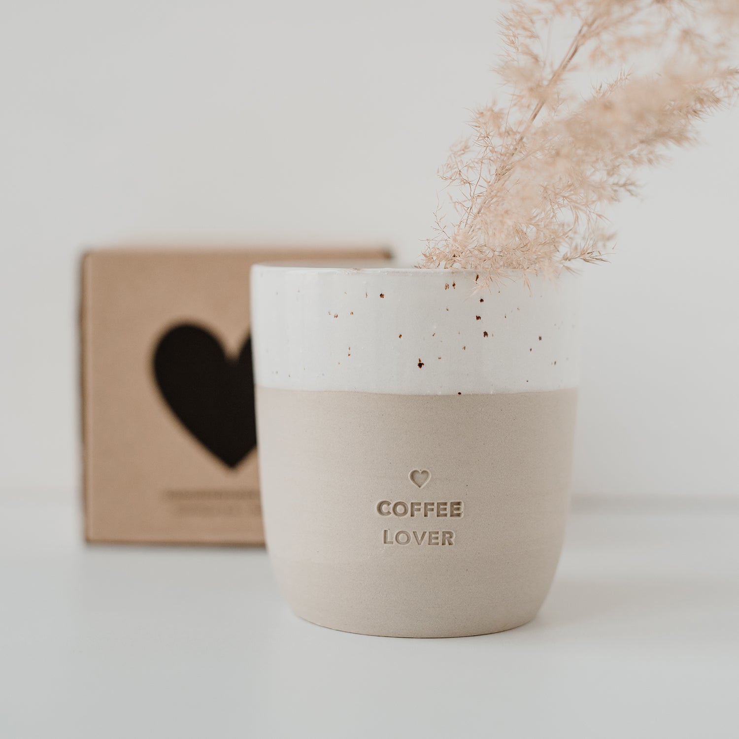 Becher Coffee Lover mit Trockenblume und Schachtel im Hintergrund