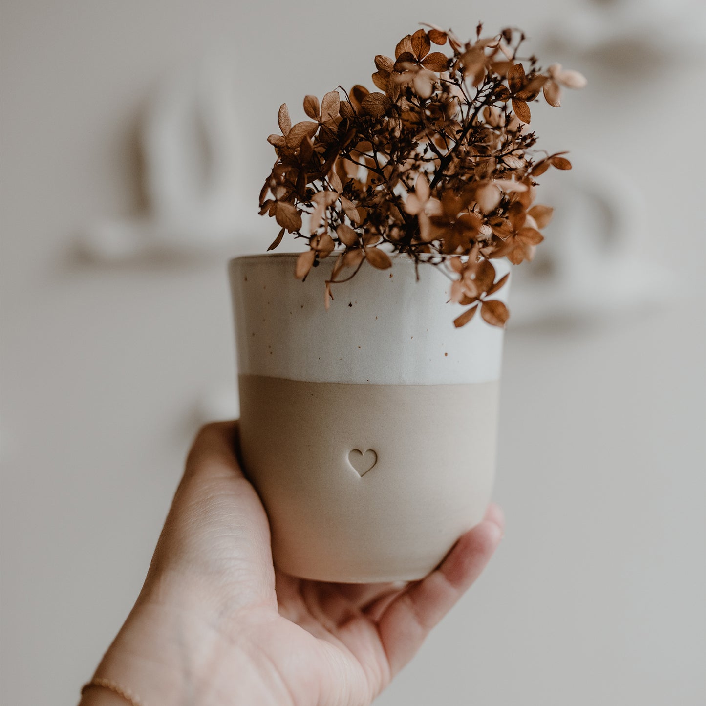 Becher Herz mit Trockenblumen in Hand